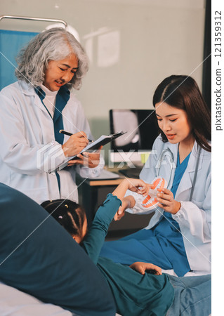 A team of doctors and nurses are working to treat a female patient in the patient's room. 121359312