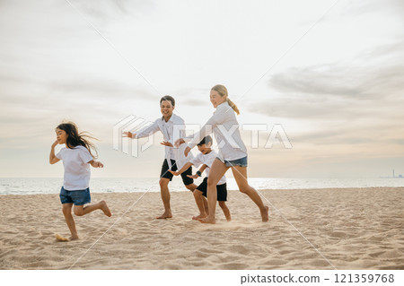 A joyful family on the beach parents and children walking playing and laughing. Summer holiday fun carefree moments and quality family time with smiles and happiness. Family on beach vacation A joyful family on the beach parents and children walking playing and laughing. Summer holiday fun carefree moments and quality family time with smiles and happiness. Family on beach vacation 121359768