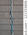 The exterior wall of a house where the sealant had deteriorated and peeled off 121359806