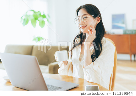 A woman using a personal computer at home 121359844