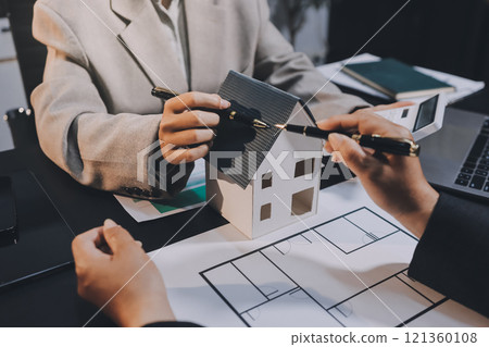 Close up Business people or Real Estate agent explain signing agreement for sale house to client. Property, Insurance, Broker concept. Close up Business people or Real Estate agent explain signing agreement for sale house to client. Property, Insurance, Broker concept. 121360108