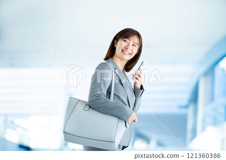 A woman in a suit going to work, an office lady walking through a bright lobby, a working office lady A woman in a suit going to work, an office lady walking through a bright lobby, a working office lady 121360386