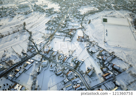 Aerial view of residential houses with snow covered roofops in suburban rural town area in winter 121360758