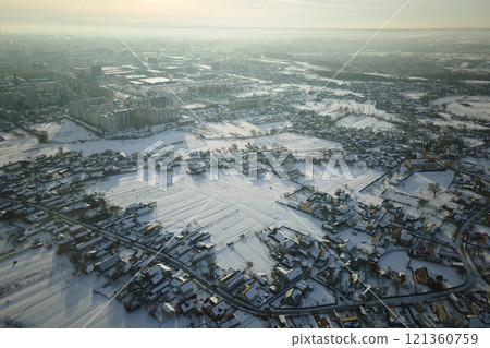 Aerial view of residential houses with snow covered roofops in suburban rural town area in winter Aerial view of residential houses with snow covered roofops in suburban rural town area in winter 121360759