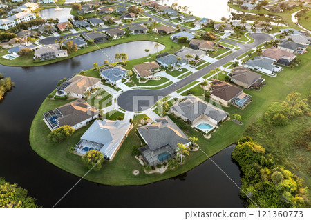 Aerial view of private homes in Florida residential area at sunset. New family houses as example of real estate development in American suburbs Aerial view of private homes in Florida residential area at sunset. New family houses as example of real estate development in American suburbs 121360773