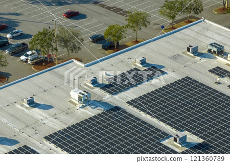 Aerial view of many photovoltaic panels installed on shopping mall roof top for producing of green ecological electricity. Production of sustainable energy concept Aerial view of many photovoltaic panels installed on shopping mall roof top for producing of green ecological electricity. Production of sustainable energy concept 121360789