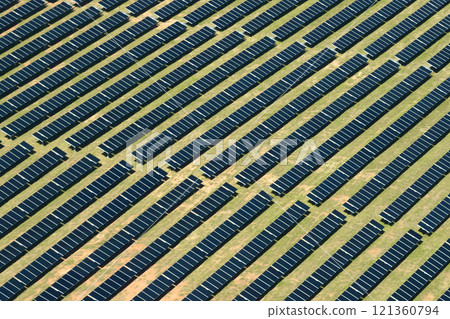Aerial view of large sustainable electrical power plant with rows of solar photovoltaic panels for producing clean electric energy. Concept of renewable electricity with zero emission Aerial view of large sustainable electrical power plant with rows of solar photovoltaic panels for producing clean electric energy. Concept of renewable electricity with zero emission 121360794