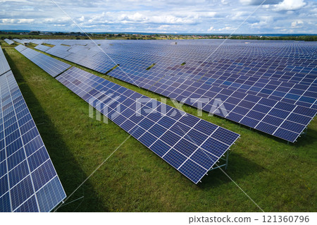 Aerial view of large sustainable electrical power plant with rows of solar photovoltaic panels for producing clean electric energy. Concept of renewable electricity with zero emission Aerial view of large sustainable electrical power plant with rows of solar photovoltaic panels for producing clean electric energy. Concept of renewable electricity with zero emission 121360796