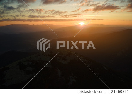 Aerial view of foggy evening over high peak with dark pine forest trees at bright sunset. Amazingl scenery of wild mountain woodland at dusk Aerial view of foggy evening over high peak with dark pine forest trees at bright sunset. Amazingl scenery of wild mountain woodland at dusk 121360815