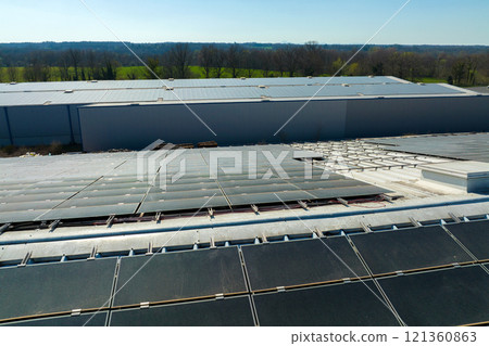 Aerial view of blue photovoltaic solar panels mounted on industrial building roof for producing green ecological electricity. Production of sustainable energy concept 121360863