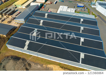 Aerial view of blue photovoltaic solar panels mounted on industrial building roof for producing green ecological electricity. Production of sustainable energy concept Aerial view of blue photovoltaic solar panels mounted on industrial building roof for producing green ecological electricity. Production of sustainable energy concept 121360864