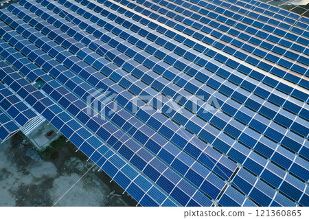 Aerial view of blue photovoltaic solar panels mounted on industrial building roof for producing green ecological electricity. Production of sustainable energy concept 121360865