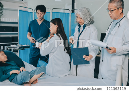 A team of doctors and nurses are working to treat a female patient in the patient's room. A team of doctors and nurses are working to treat a female patient in the patient's room. 121362119