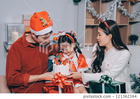 Father, mother and child celebrating Christmas. 121362164