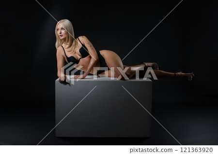 Model posing elegantly on a pedestal in a minimalist studio environment Model posing elegantly on a pedestal in a minimalist studio environment 121363920