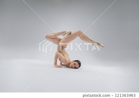 Ballerina performing an impressive dance pose on a neutral background Ballerina performing an impressive dance pose on a neutral background 121363963