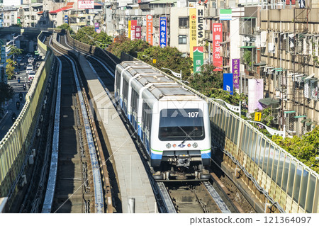 View of a Wenhu or Brown line train running on the elevated track of the Taipei Mass Rapid Transit System with the building background. 121364097