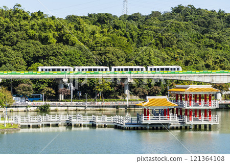 A train traveling on the Wenhu or Brown Line of the Taipei MRT, Taiwan, passes by Taipei Dahu Park. 121364108