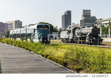 The circular light rail train drives past Hamasen Railway Cultural Park in Kaohsiung, Taiwan. The circular light rail train drives past Hamasen Railway Cultural Park in Kaohsiung, Taiwan. 121364417