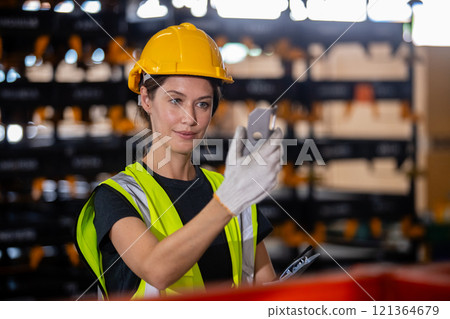 Female professional quality checking car parts worker in warehouse. Supervisor import-export shipping transportation, logistic business factory concept. 121364679