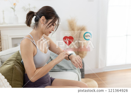 Women Point to smartwatch displaying heart rate application. Monitoring virtual display measure heart rate before after physical exercise. wristwatch checking heart beats and pulse. 121364926