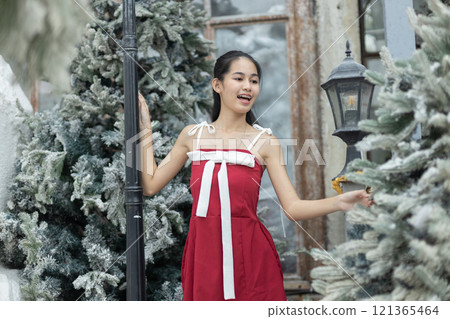Portrait of young asian beautiful woman happy smiling with snow on Christmas Day with braces. Happy girl in good mood smile showing teeth. Portrait of young asian beautiful woman happy smiling with snow on Christmas Day with braces. Happy girl in good mood smile showing teeth. 121365464