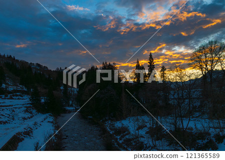 A beautiful sunset in a snowy country with a contrast of colors 121365589