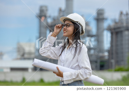 Engineer with blueprint working factory producing electricity oil energy. Construction manager oil refinery in petrochemical. improvement inspector Industrial worker working power plant 121365900
