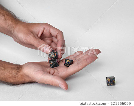Hands holding polyhedral dice for dungeons and dragons game session Hands holding polyhedral dice for dungeons and dragons game session 121366099