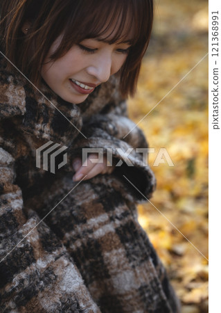 A young woman with a short bob enjoying autumn leaves A young woman with a short bob enjoying autumn leaves 121368991