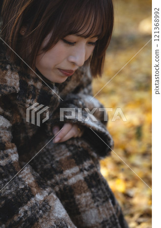 A young woman with a short bob enjoying autumn leaves A young woman with a short bob enjoying autumn leaves 121368992