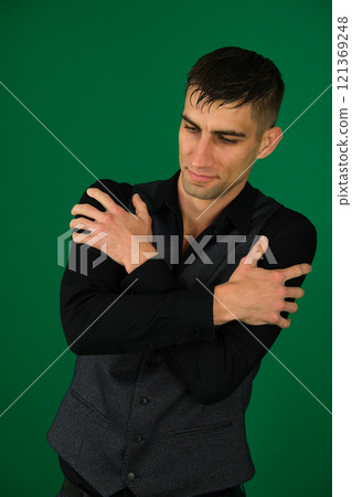Handsome young man hugging himself on blue background 121369248
