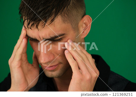 Unhealthy man suffering from migraines or dizziness sits on the couch at home, feels pain in his head. He is stressed, experiencing vertigo or headache, worrying about work or relationship problems. 121369251