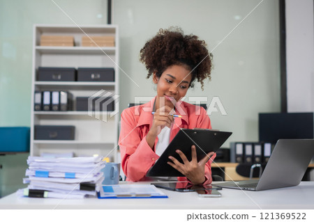 Businesswomen hand working with tablet and laptop computer with documents on office desk in modern office. 121369522