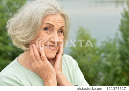 Portrait of a beautiful elderly woman in the park Portrait of a beautiful elderly woman in the park 121373817