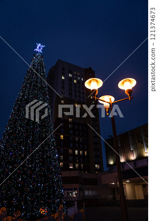 New Year's tree on the background of a multi-storey building and a street lamp New Year's tree on the background of a multi-storey building and a street lamp 121374673