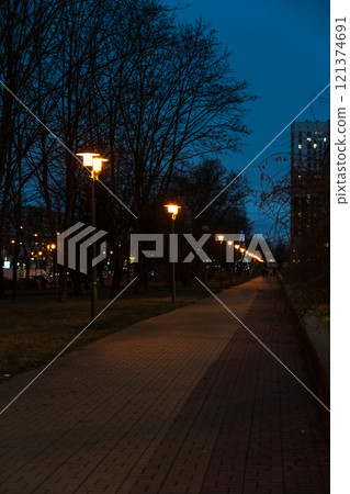 A pedestrian path illuminated by lanterns in the evening, in December 121374691