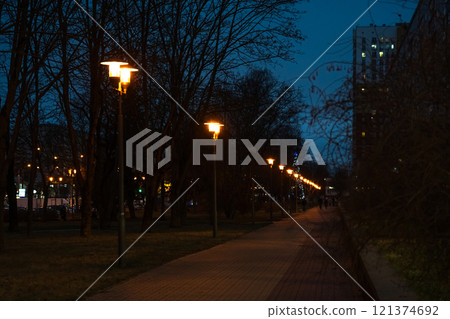 A pedestrian path illuminated by lanterns in the evening, in December 121374692