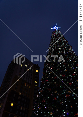 New Year's tree on the background of a multi-storey building 121374717