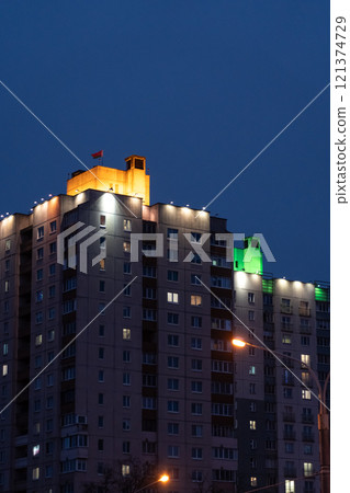 Illuminated panel, multi-storey buildings in the distance. An evening in Minsk Illuminated panel, multi-storey buildings in the distance. An evening in Minsk 121374729