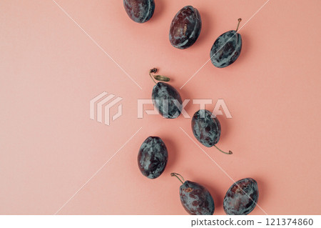 Top view photo of whole plums on isolated pastel pink background Top view photo of whole plums on isolated pastel pink background 121374860