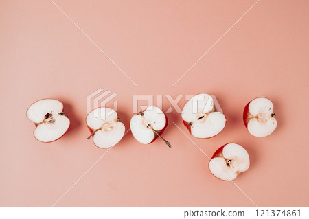 Red apple, half apple and quarter apple on pink background. Top view, healthy food concept. Top view. Red apple, half apple and quarter apple on pink background. Top view, healthy food concept. Top view. 121374861