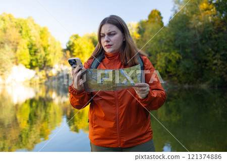 Traveling Happy Caucasian woman with backpack used phone walking on path the mountain forest looking at the camera and map. Summer holiday and vacation trip  121374886