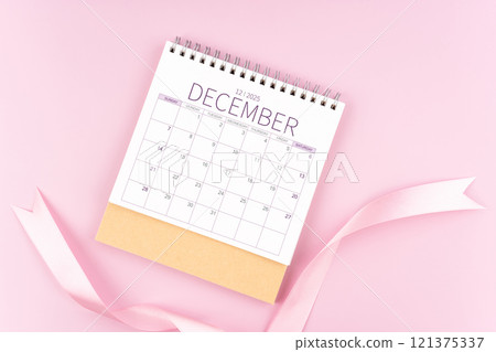 December 2025 desk calendar with pink pastel ribbon. 121375337