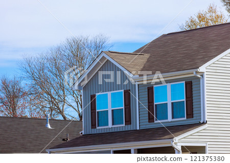 View of upper section of suburban house featuring grey siding, multiple windows, brown shutters under with suburban at American town View of upper section of suburban house featuring grey siding, multiple windows, brown shutters under with suburban at American town 121375380