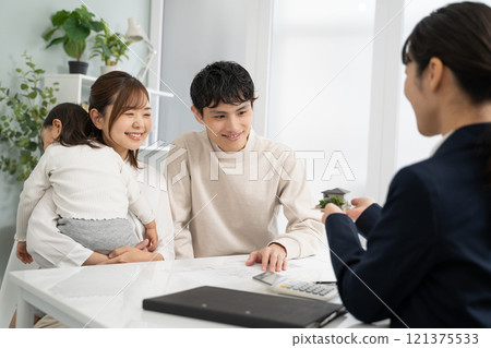 Businesswomen discussing design using a model of a house 121375533