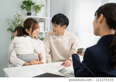 Businesswomen discussing design using a model of a house Businesswomen discussing design using a model of a house 121375534