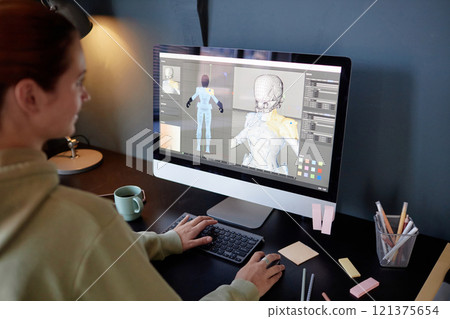 Individual working on 3D modeling software on desktop, creating skeletal structure. Various office supplies scattered on desk, showing artistic process Individual working on 3D modeling software on desktop, creating skeletal structure. Various office supplies scattered on desk, showing artistic process 121375654