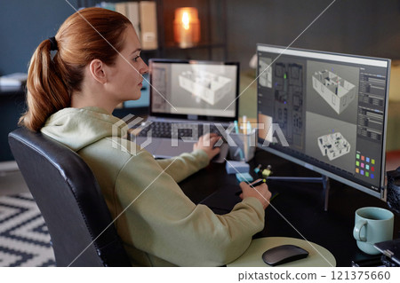Someone focused on creating 3D models on professional computer setup in an office workspace equipped with multiple screens and other desk accessories Someone focused on creating 3D models on professional computer setup in an office workspace equipped with multiple screens and other desk accessories 121375660