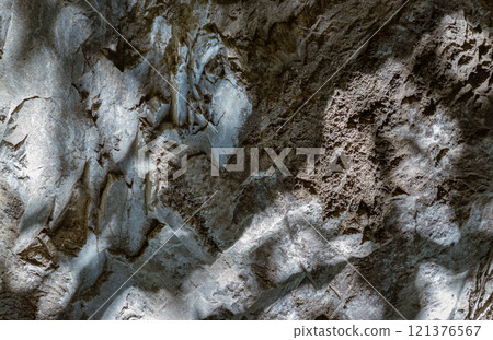 Elegance of The intricate natural light and shadow on surface of stone wall. 121376567